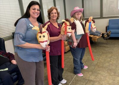 Three women carry inflatable hobby horses